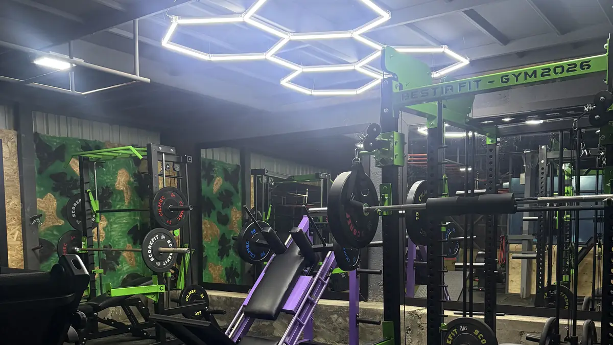 Rack y máquinas de Bestia Fit Gym bajo las luces hexagonales